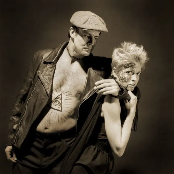 A black and white photo of a man and woman with tattoos.